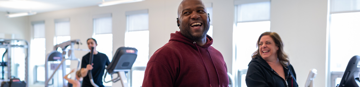 Photograph of people smiling at a fitness center.